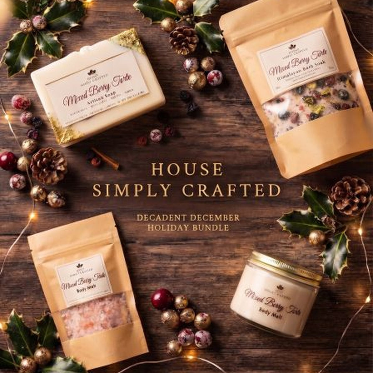 Decadent December holiday bundle in Mixed Berry Torte: artisan soap, bath soak pouches and body melt jar styled on a wood table with holly and string lights (styled preview image)